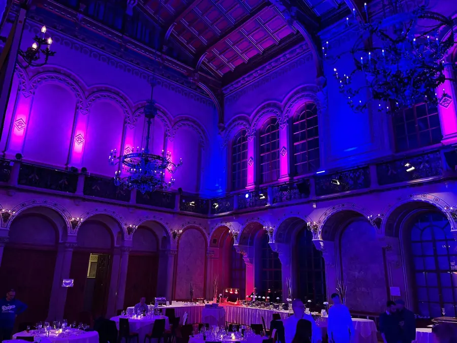Elegant gedeckter Hochzeitssaal mit Dinner-Tischen und stimmungsvoller Ambientebeleuchtung