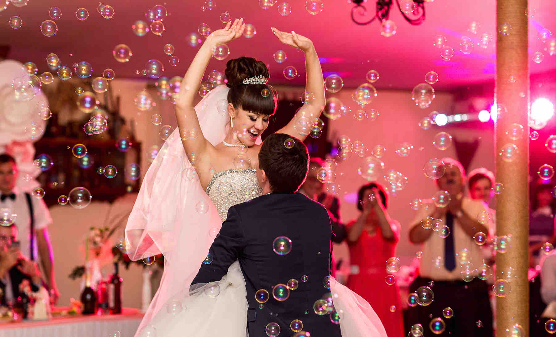 Brautpaar beim ausgelassenen Hochzeitstanz mit Seifenblasen