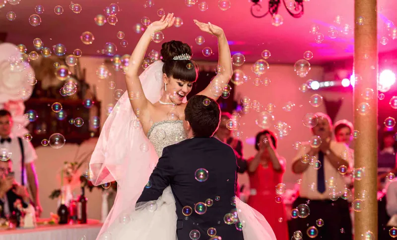 Brautpaar beim ausgelassenen Hochzeitstanz mit Seifenblasen