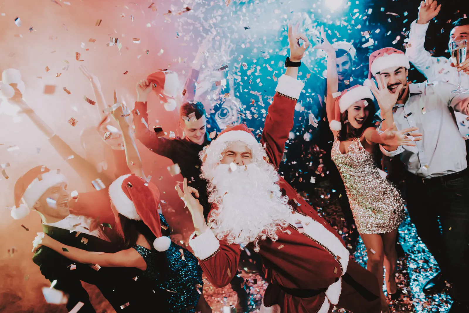 Weihnachtsfeier mit Weihnachtsmann, Konfetti und tanzenden Gästen